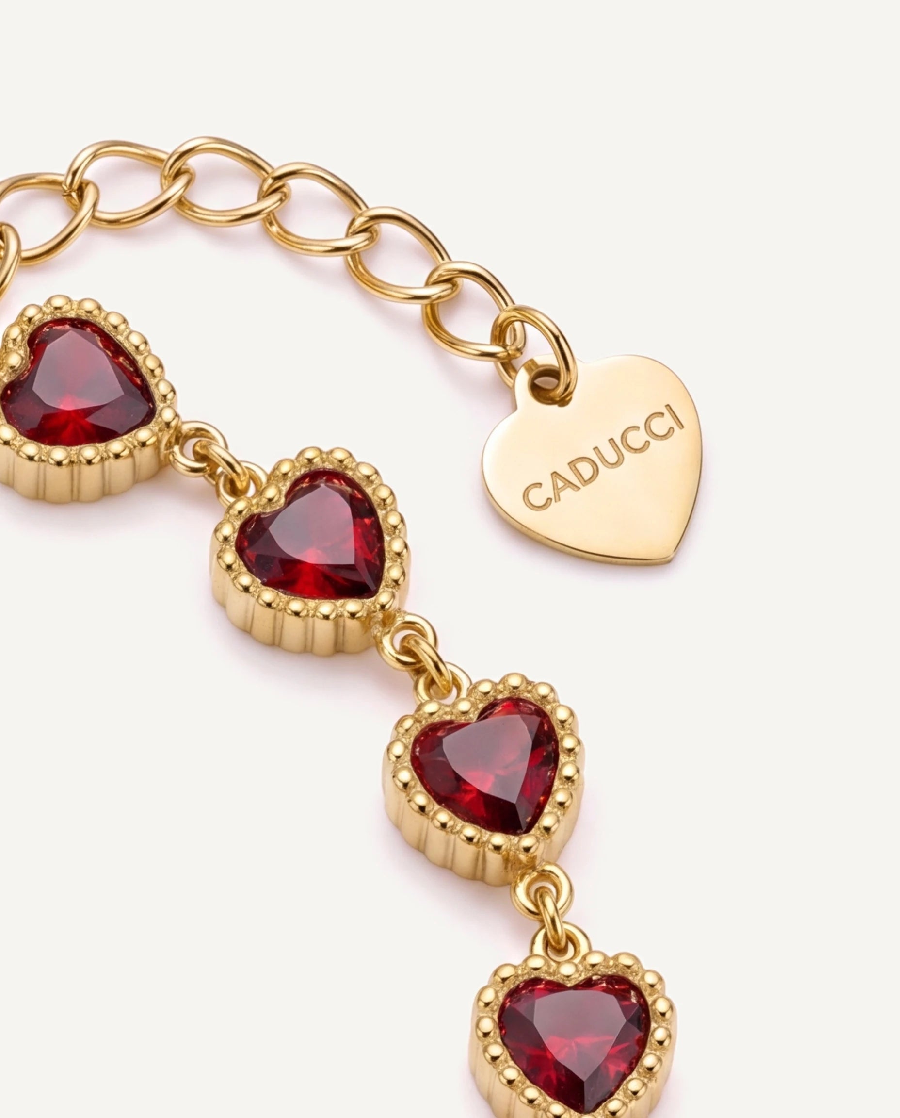 CADUCCI Amore Bracelet with red heart stones, close-up of the heart charm engraved with the CADUCCI logo
