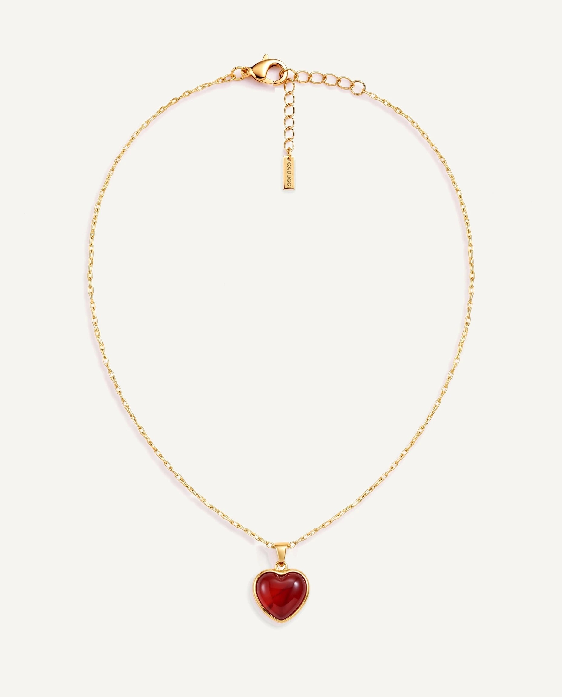 CADUCCI Amore Necklace in gold with a red heart pendant in a smooth bezel and a rectangular tag engraved with the CADUCCI logo