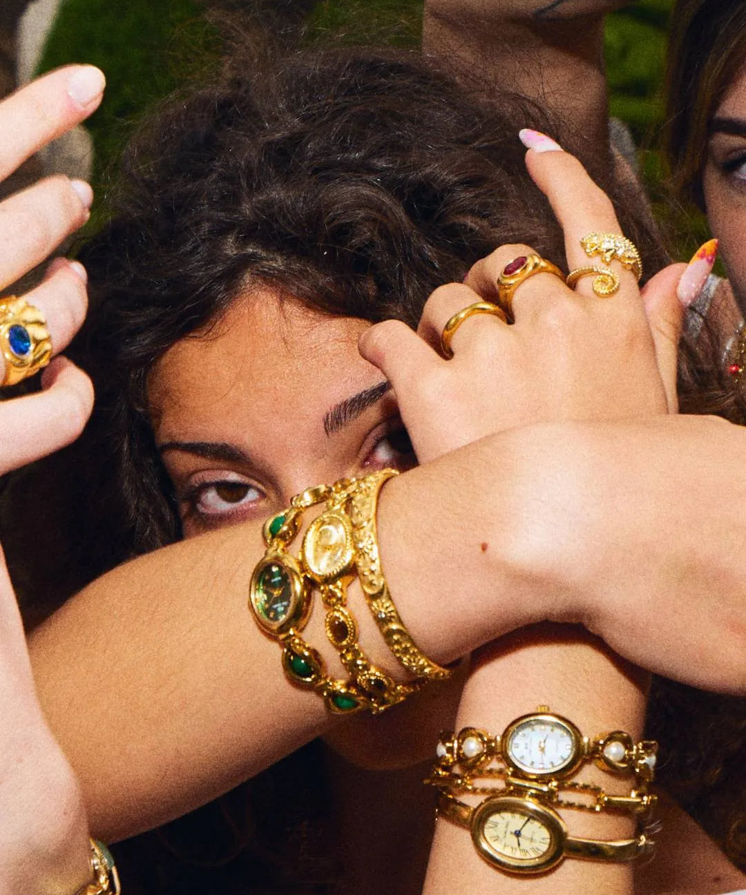 Woman wearing the CADUCCI Belluno Bracelet in gold stacked with vintage-style gold watches