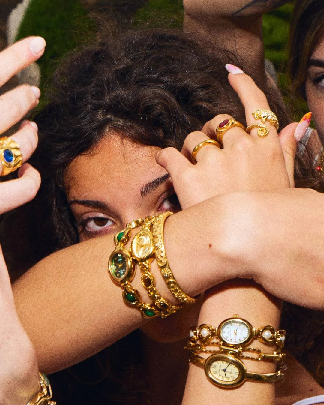 Woman wearing the CADUCCI Belluno Bracelet in gold stacked with vintage-style gold watches