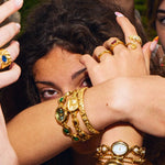 Woman wearing the CADUCCI Belluno Bracelet in gold stacked with vintage-style gold watches