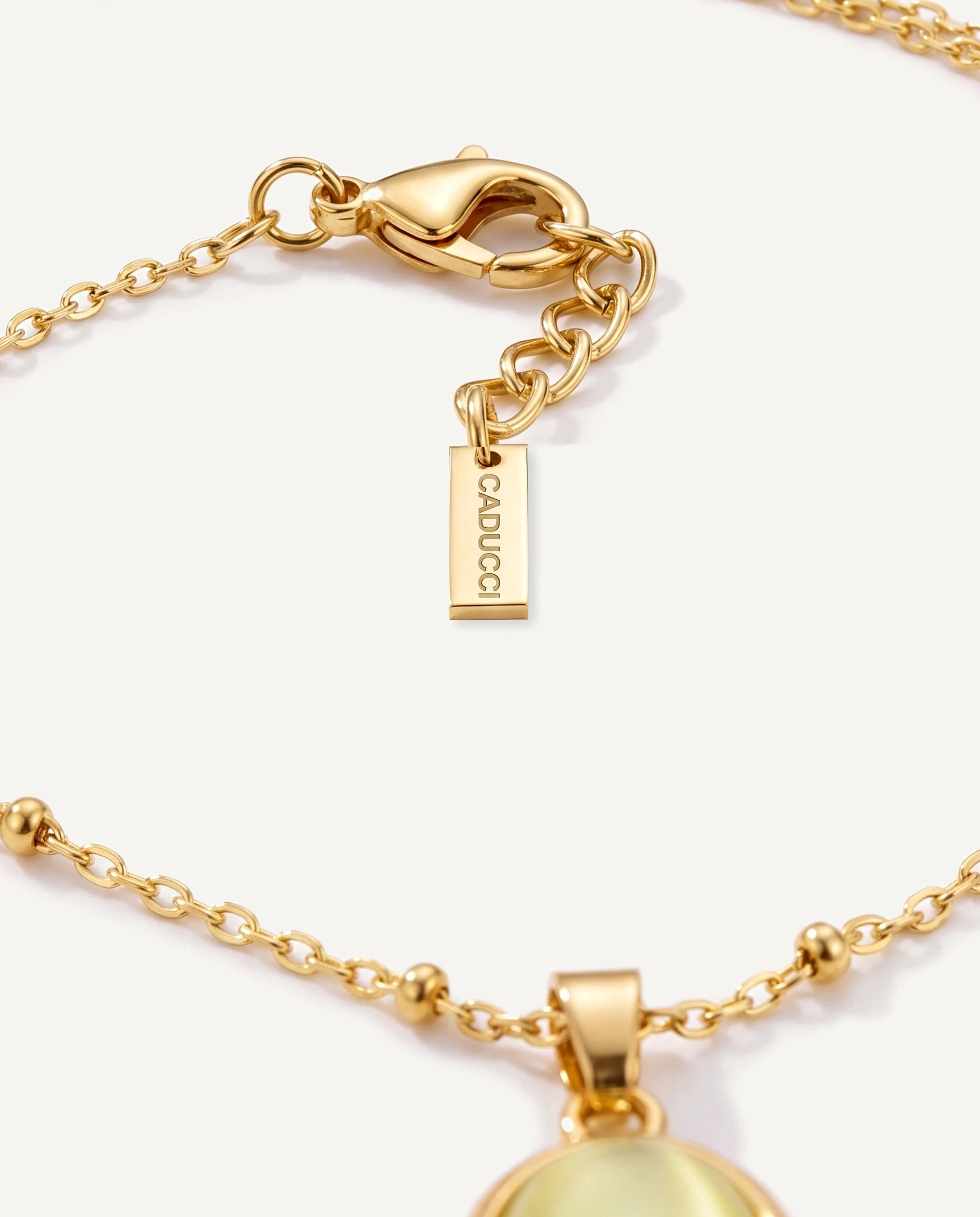 CADUCCI Capri Necklace in gold, close-up of the satellite chain, the clasp and the tag engraved with the CADUCCI logo