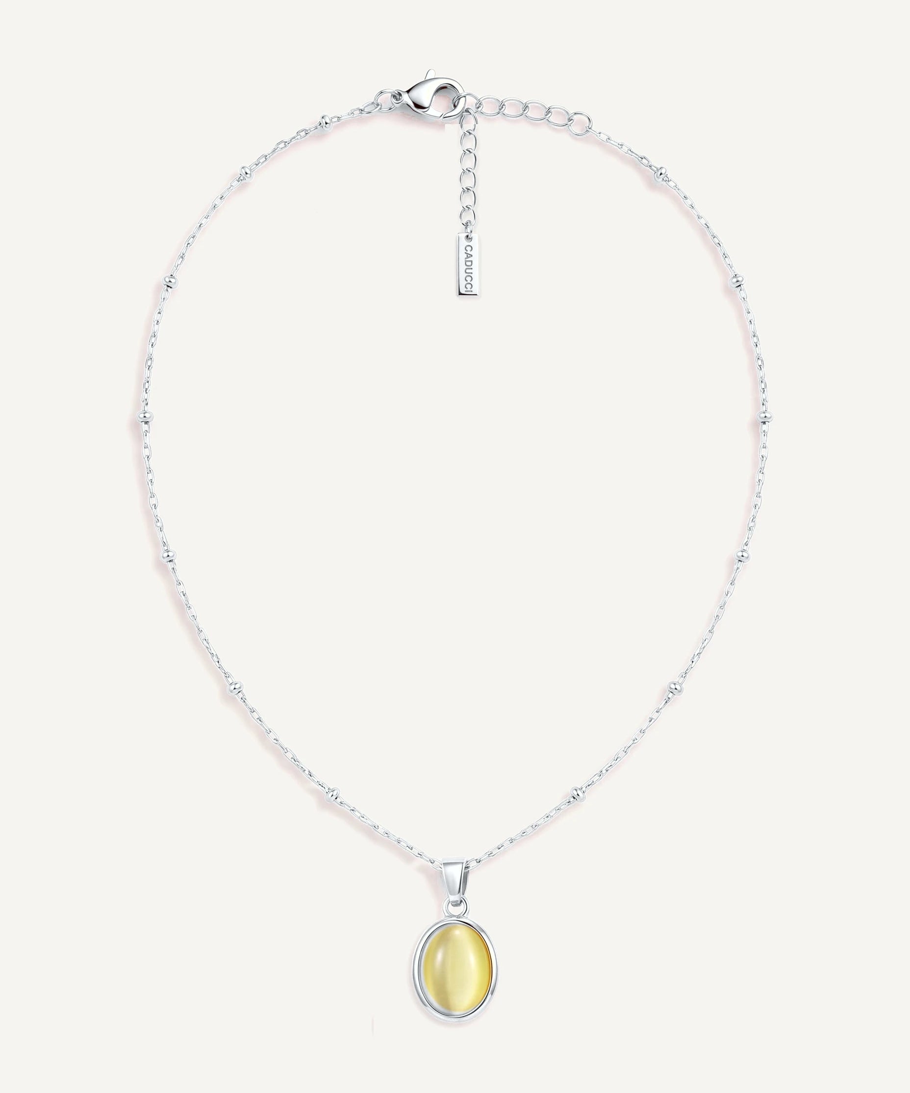 CADUCCI Capri Necklace in silver with an oval pale green cat's-eye pendant in a smooth bezel and a rectangular tag engraved with the CADUCCI logo