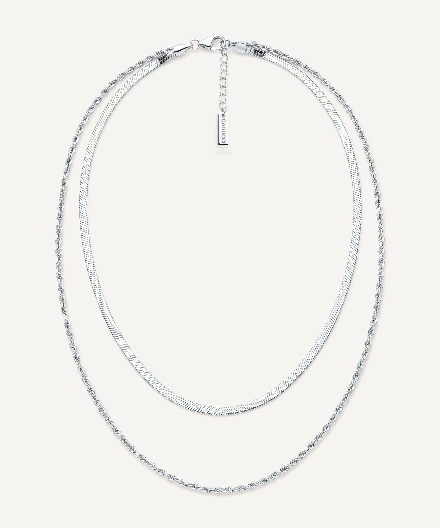 CADUCCI Firenze Necklace in silver, layered: a thin herringbone chain and a fine rope chain, with a rectangular tag engraved with the CADUCCI logo