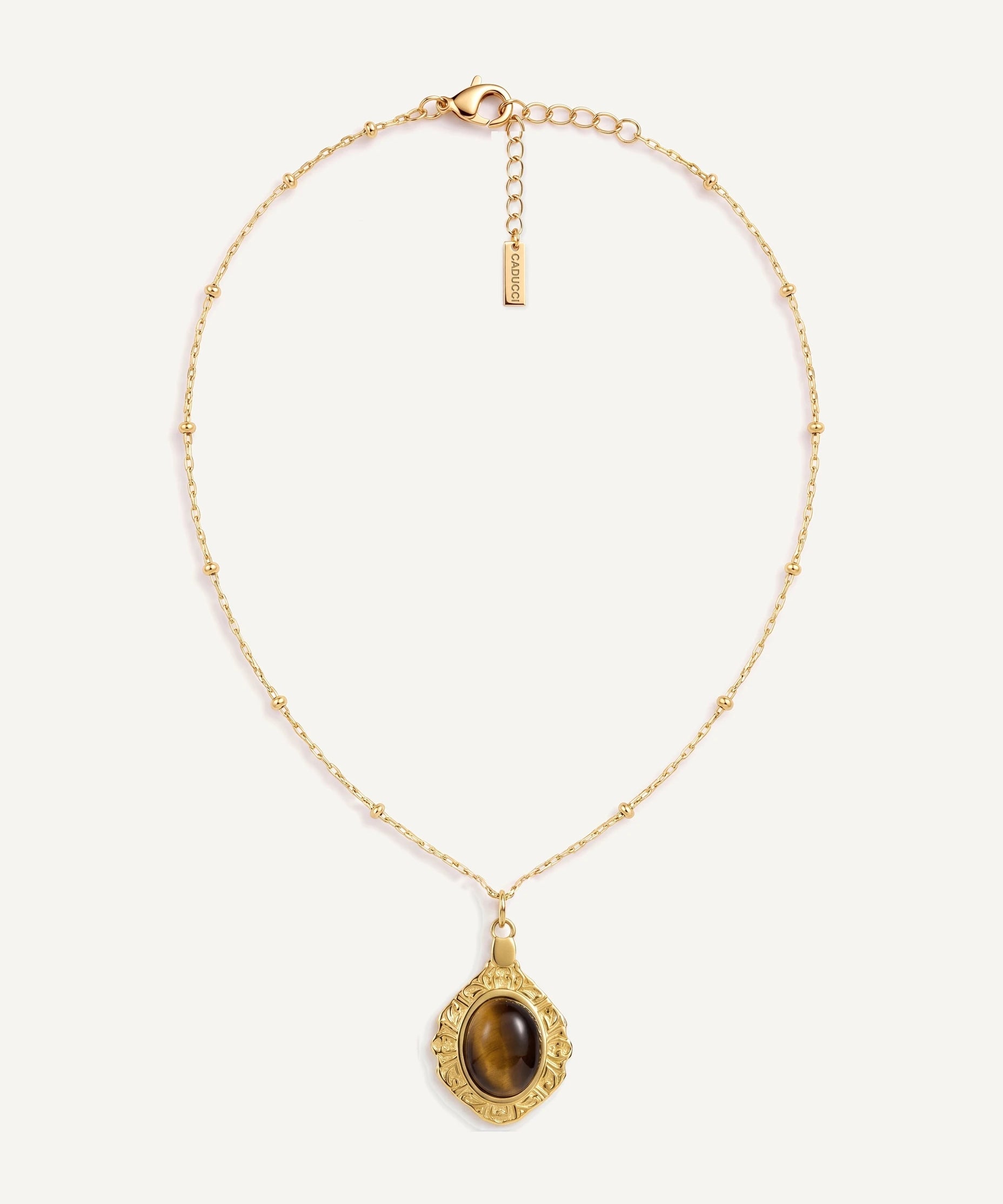 CADUCCI Luna Necklace in gold with a tiger's-eye pendant in a baroque gold frame and a rectangular tag engraved with the CADUCCI logo