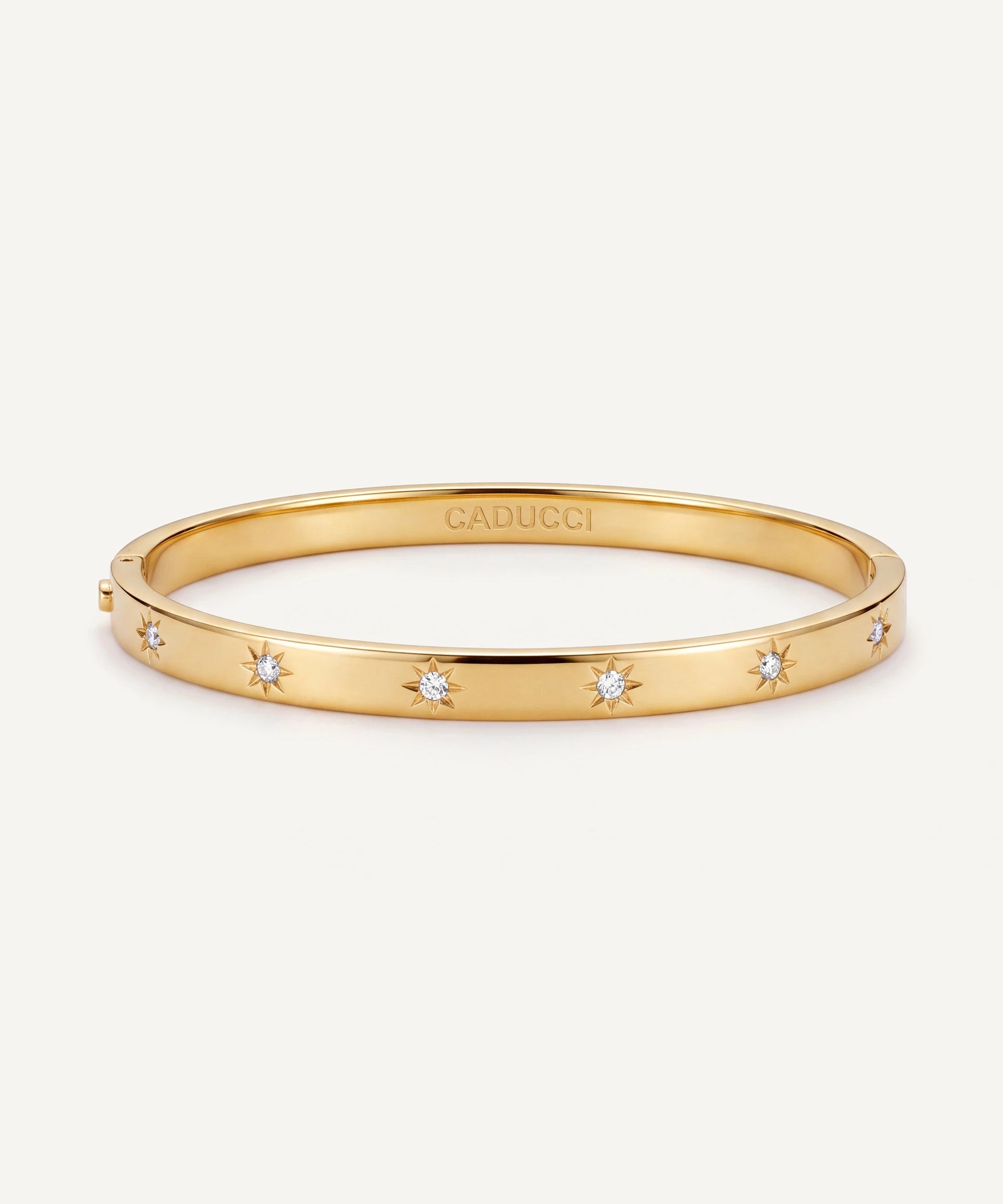 CADUCCI Venezia Bracelet in gold, slim hinged bangle with star-set crystals and the CADUCCI logo engraved inside